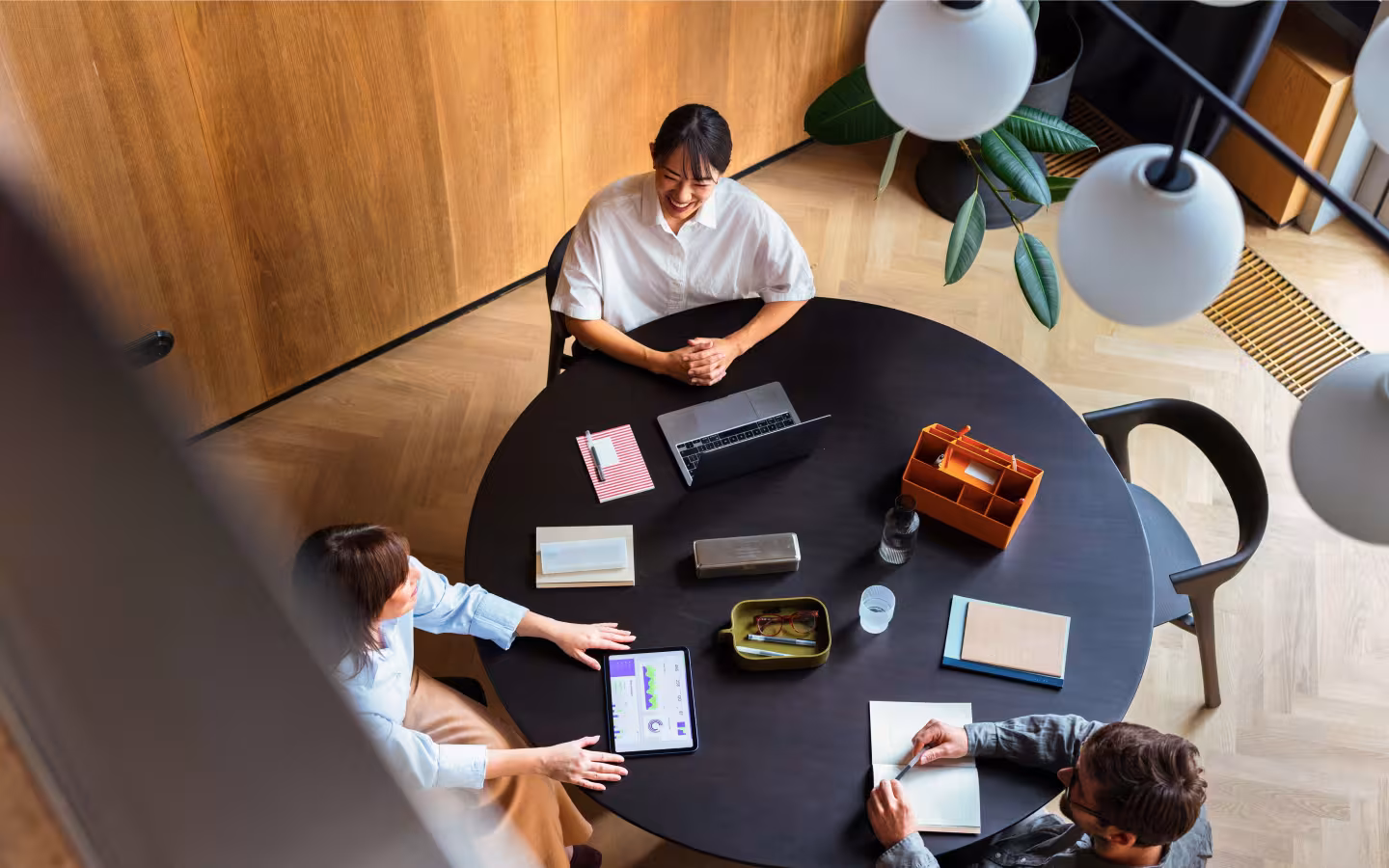 BGRE colleagues collaborating around a meeting table in a contemporary workplace.