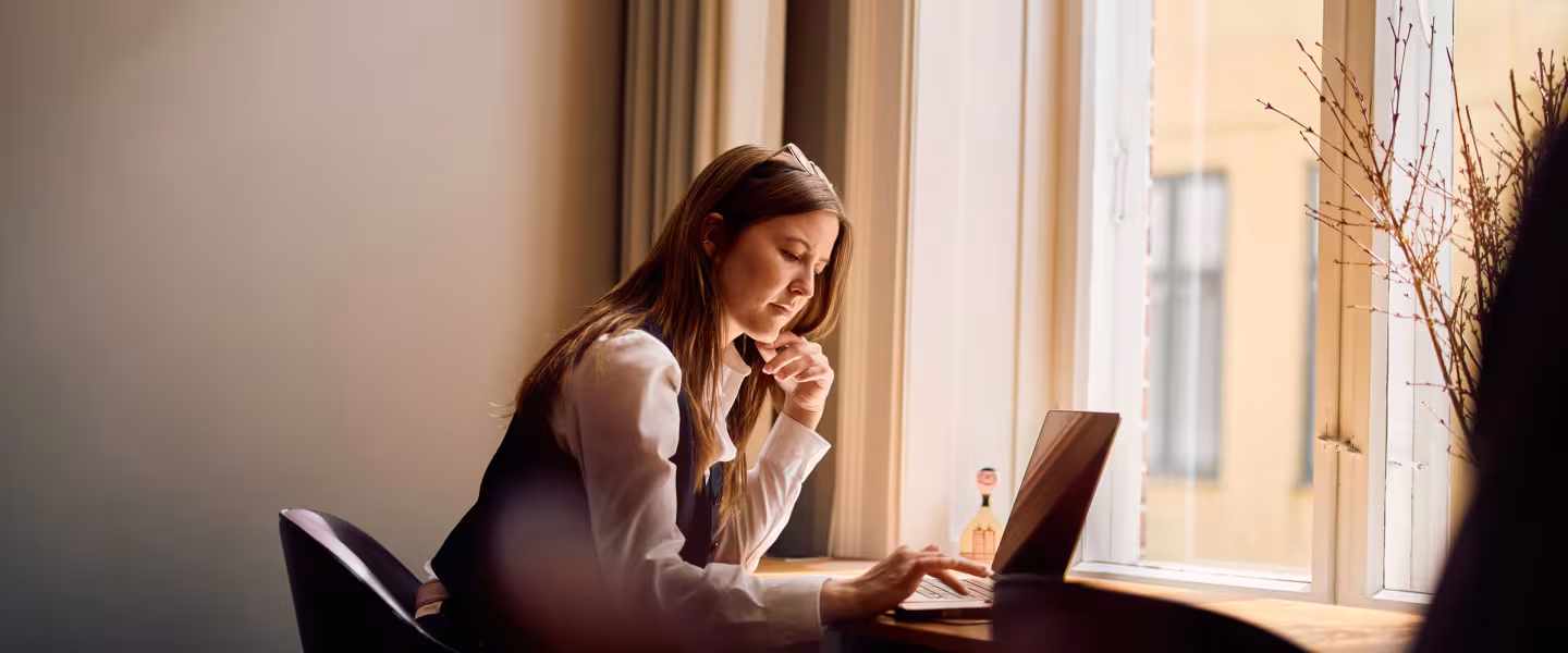 A BGRE colleague working beside a window in a modern office setting.